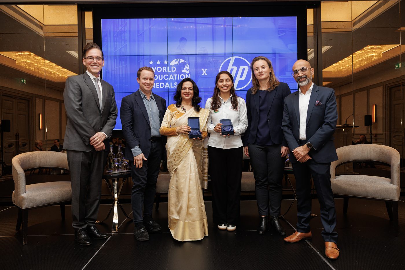 World Education Medals recipients on stage beside an HP backdrop